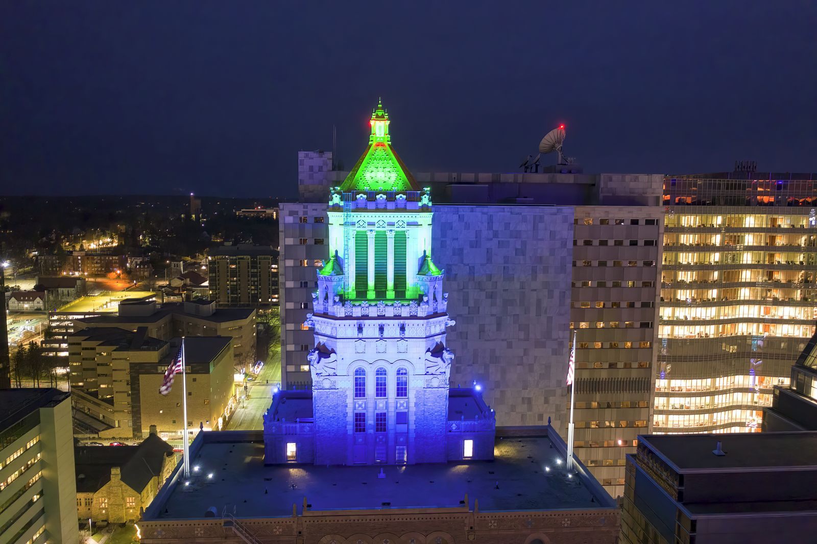 The Plummer Building tower lit in blue and green at night in downtown Rochester, Minnesota